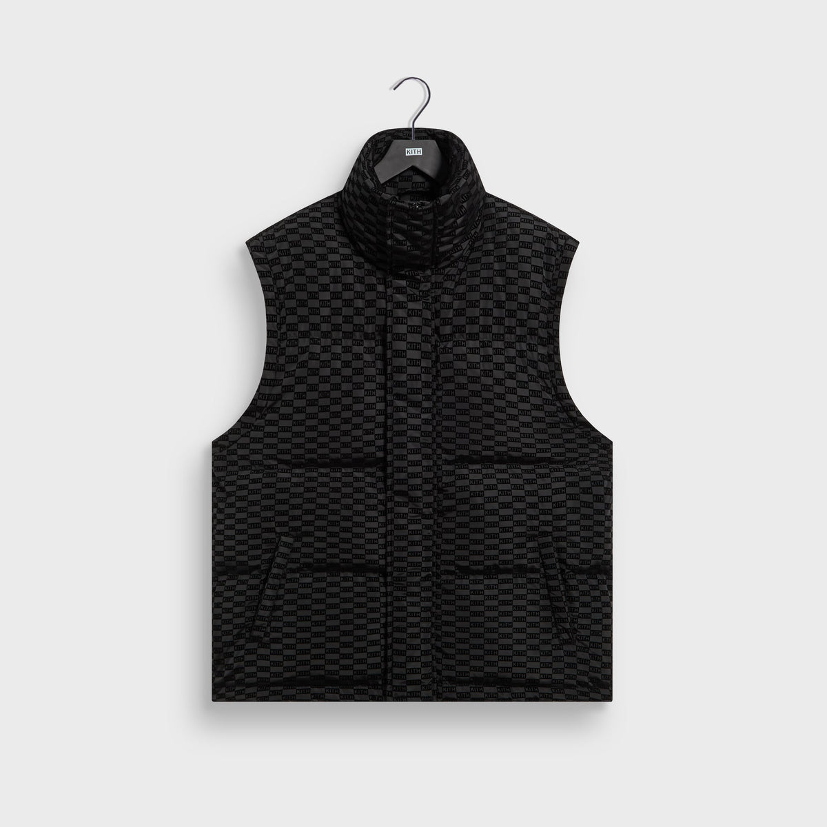 Black Kith Flocked Monogram Westley puffer worn as a vest with the sleeves removed, front view